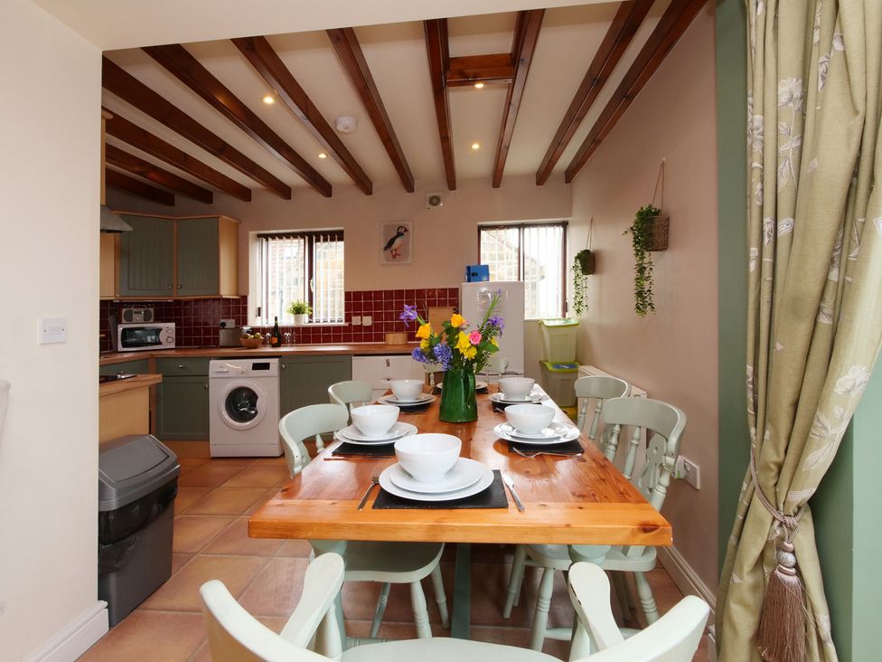 A kitchen with a dining table and chairs at Scoresby Cottage @ Summerfield Farm, Hawsker