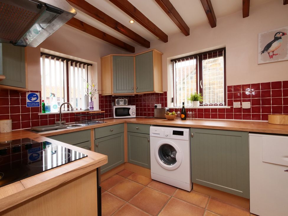 A kitchen with appliances and countertop at Scoresby Cottage @ Summerfield Farm, Hawsker