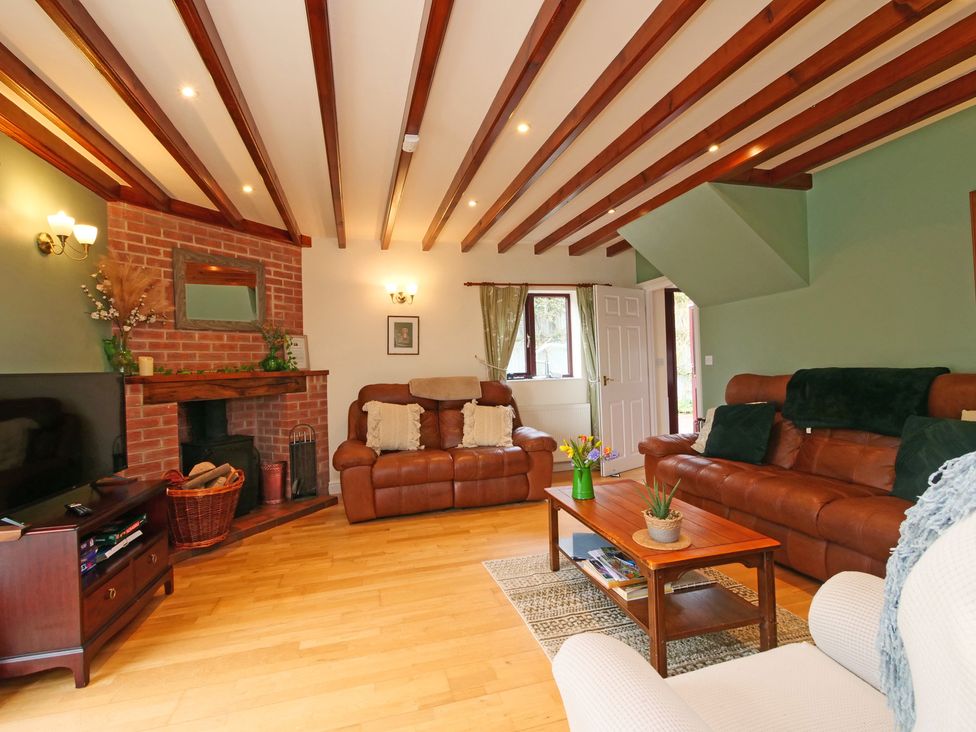 A living room with two sofas, a coffee table, and a television at Scoresby Cottage @ Summerfield Farm, Hawsker