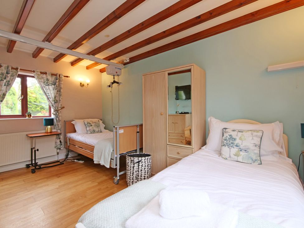 A bedroom with a bed and hospital bed at Scoresby Cottage @ Summerfield Farm, Hawsker