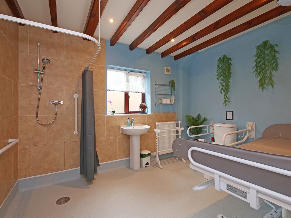 A bathroom with a shower and a sink at Scoresby Cottage @ Summerfield Farm Hawsker