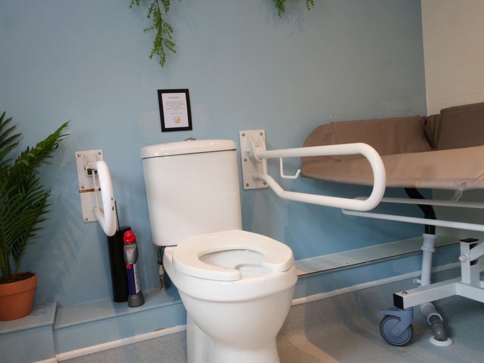 A bathroom with a toilet and hospital bed at Scoresby Cottage @ Summerfield Farm, Hawsker