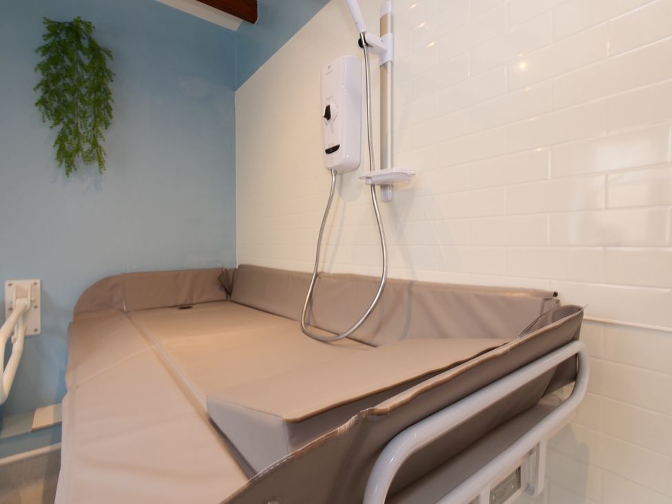 A bathroom with a shower and bath setup at Scoresby Cottage @ Summerfield Farm, Hawsker