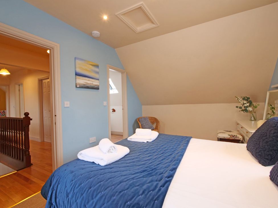 A bedroom with a bed and a chair at Scoresby Cottage @ Summerfield Farm in Hawsker