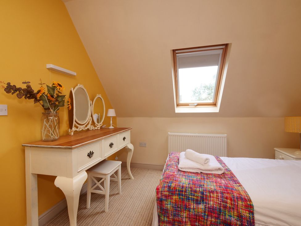 A bedroom with a vanity table and mirror at Scoresby Cottage @ Summerfield Farm in Hawsker
