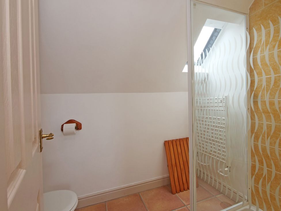 A bathroom with a toilet and shower at Scoresby Cottage @ Summerfield Farm Hawsker