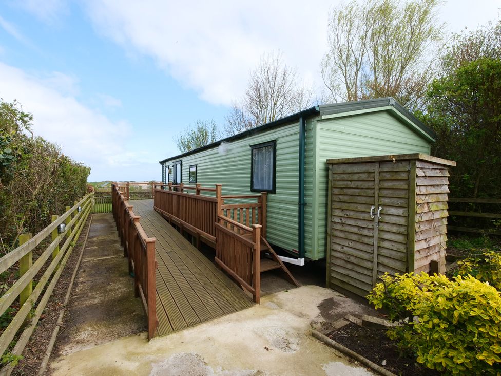 A mobile home with a wooden ramp and shed at Abbey View @ Summerfield Farm in Hawsker