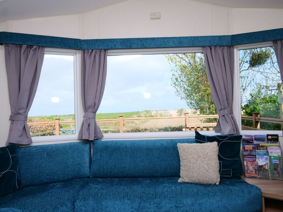 A living room with a couch and window view at Abbey View @ Summerfield Farm in Hawsker