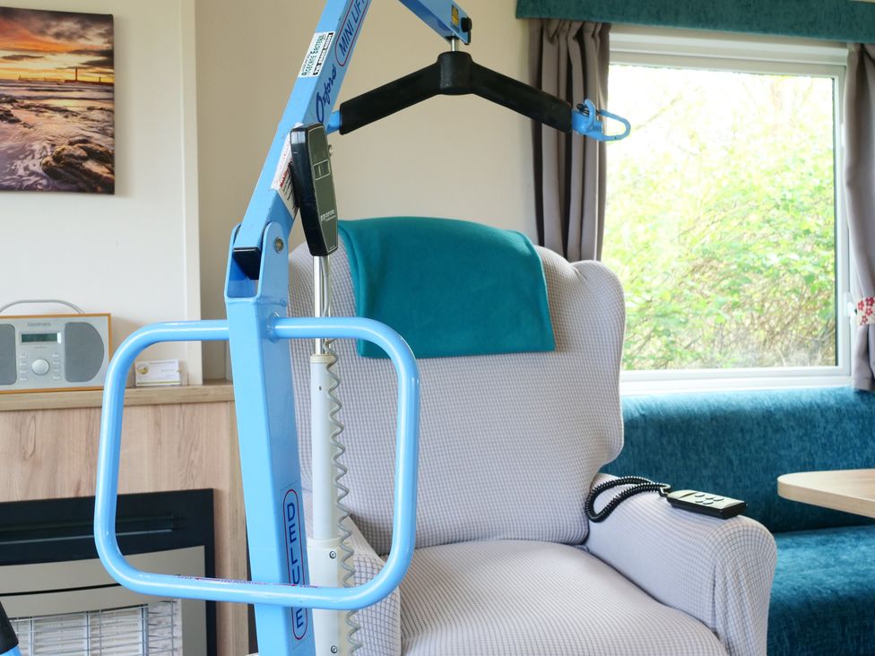 A living room with a hoist next to a chair at Abbey View @ Summerfield Farm, Hawsker