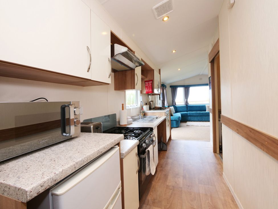 A kitchen with appliances and a view at Abbey View @ Summerfield Farm, Hawsker