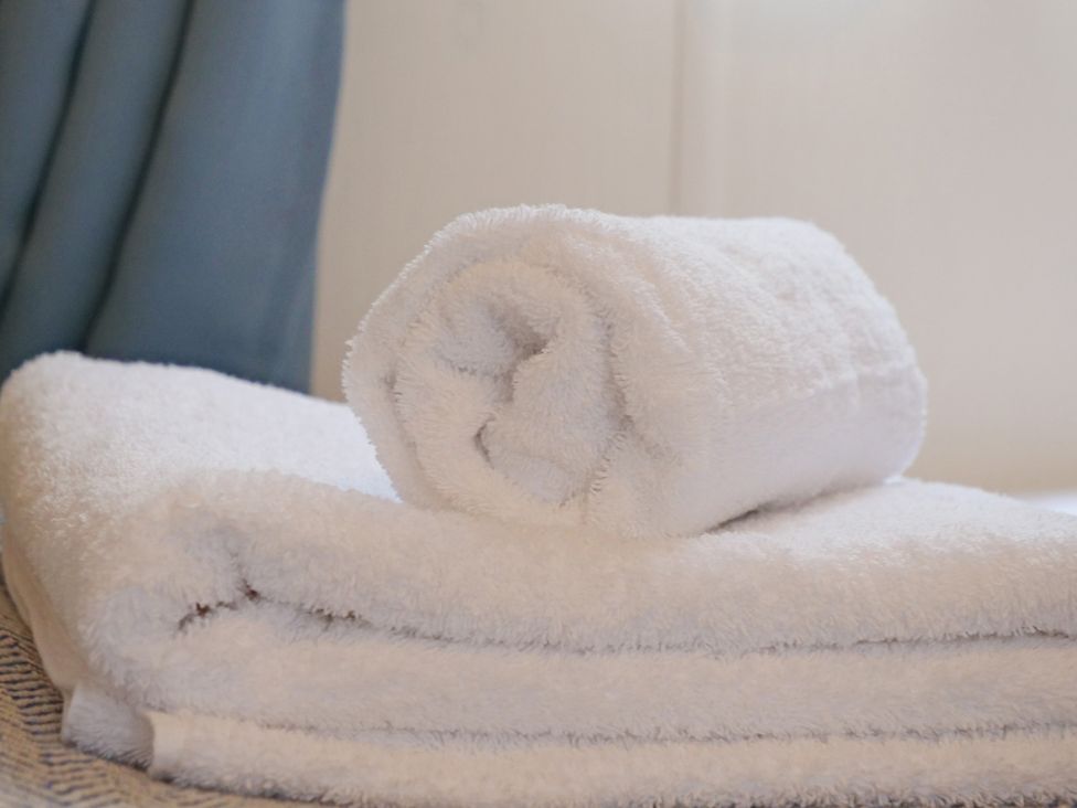 A rolled towel placed on a folded towel at Abbey View @ Summerfield Farm Hawsker