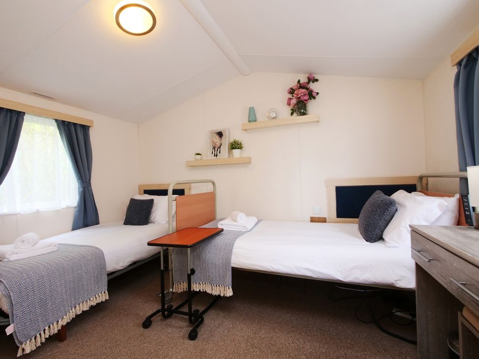 A bedroom with two beds and a shelf at Abbey View @ Summerfield Farm in Hawsker