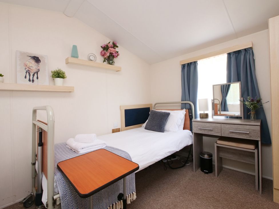 A bedroom with a bed and a table at Abbey View @ Summerfield Farm in Hawsker