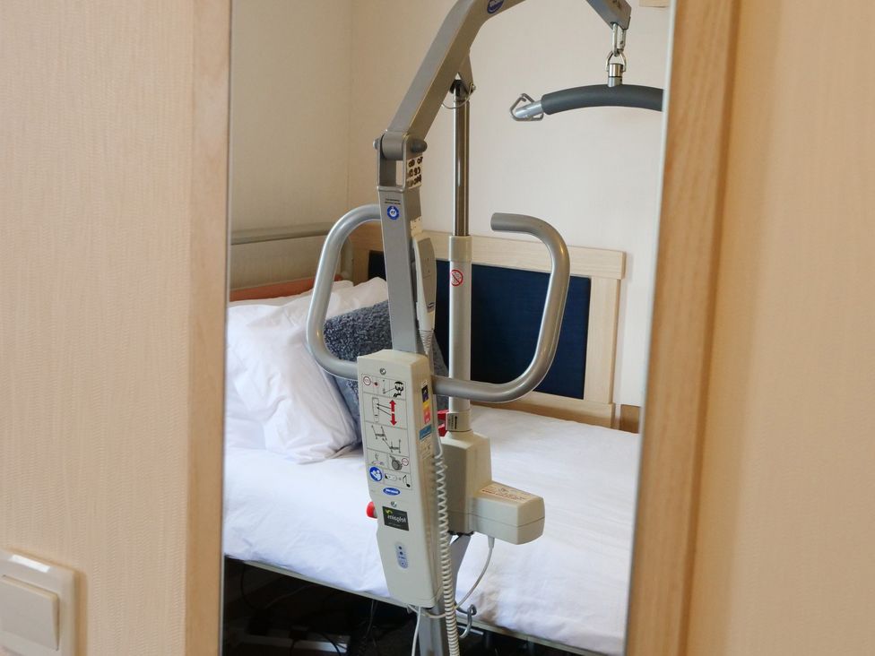 A bedroom featuring a bed and a patient lift at Abbey View @ Summerfield Farm, Hawsker