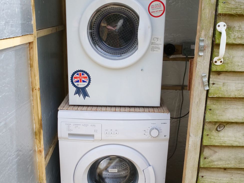 A washing machine and tumble dryer in a laundry area at Abbey View @ Summerfield Farm, Hawsker