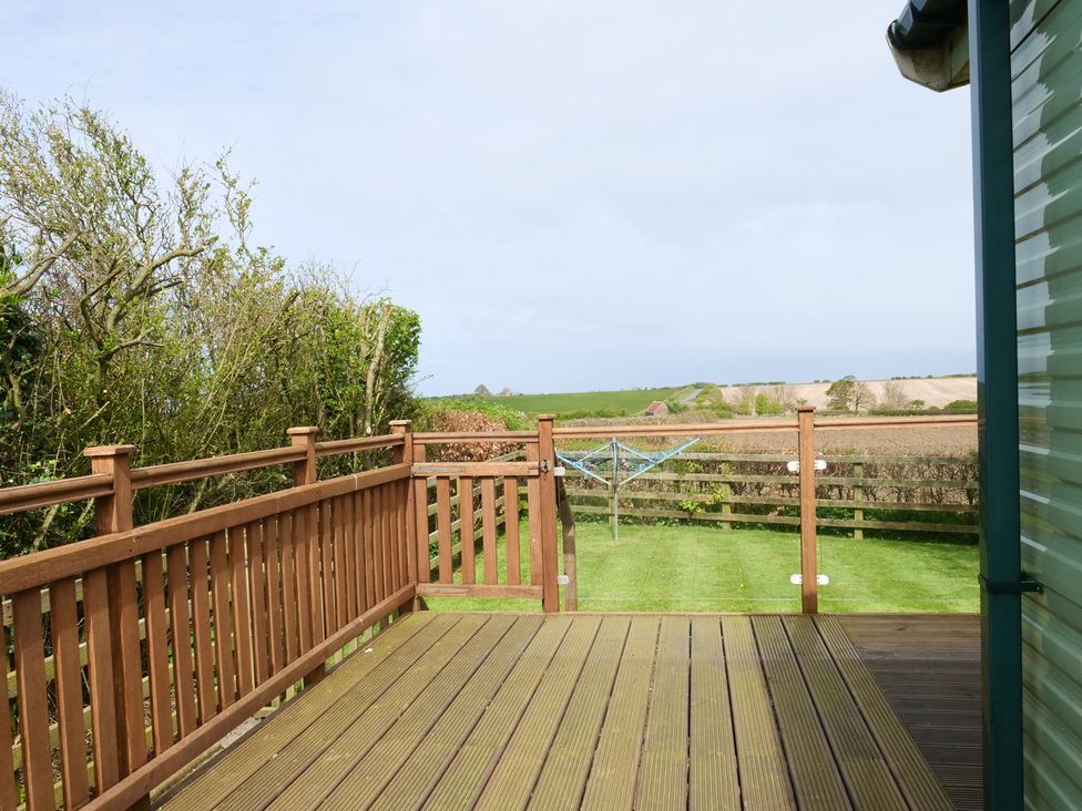 An outdoor area with decking and fence at Abbey View @ Summerfield Farm in Hawsker