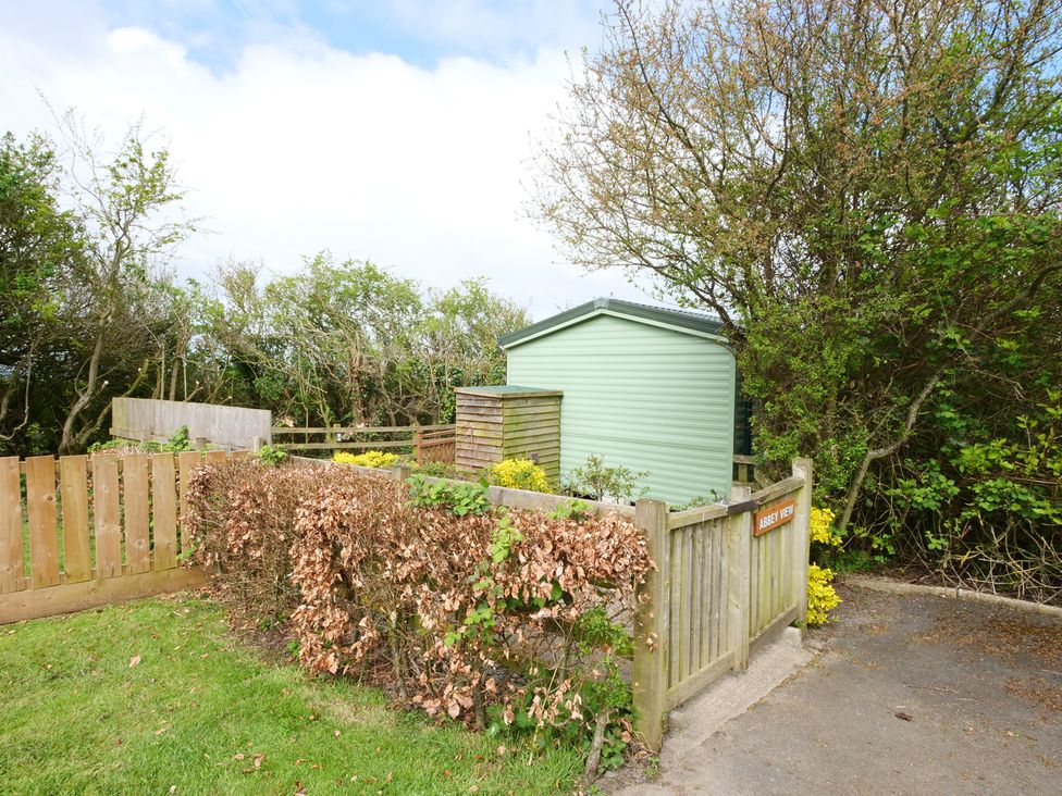 An outdoor area with a shed and wooden fence at Abbey View @ Summerfield Farm in Hawsker