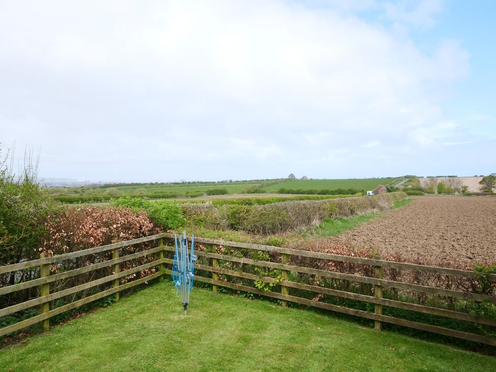 A garden with a clothesline and a view of fields at Abbey View @ Summerfield Farm in Hawsker