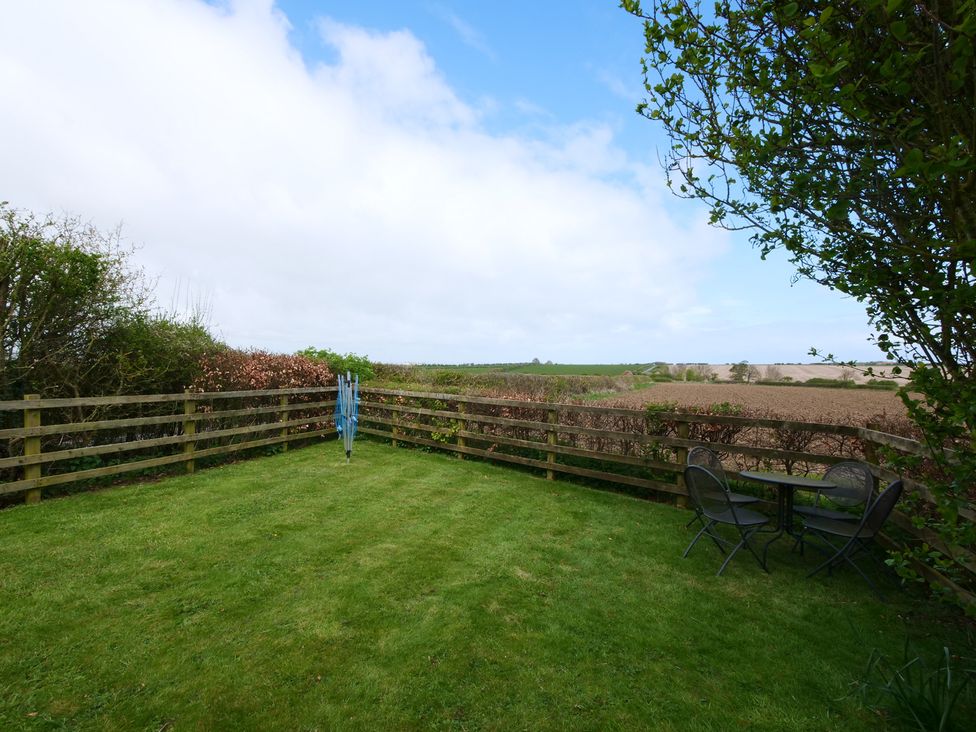 A garden with a table and chairs at Abbey View @ Summerfield Farm, Hawsker
