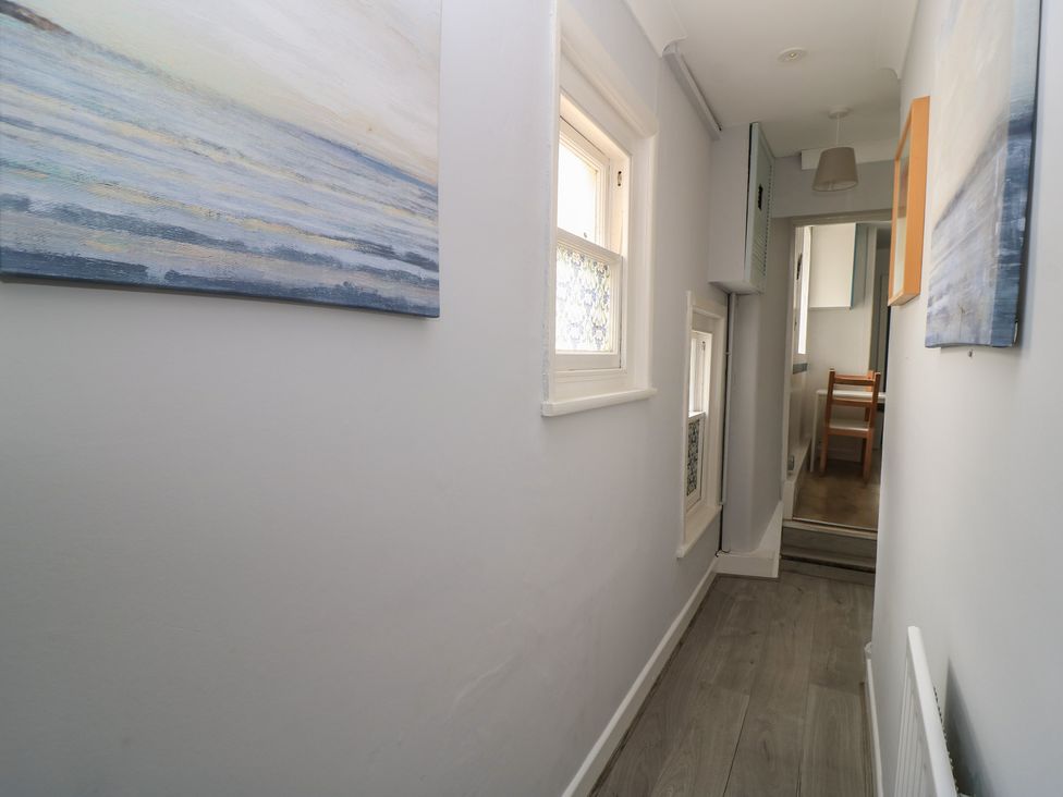 A hallway with a painting and window at Still Waters in Swanage