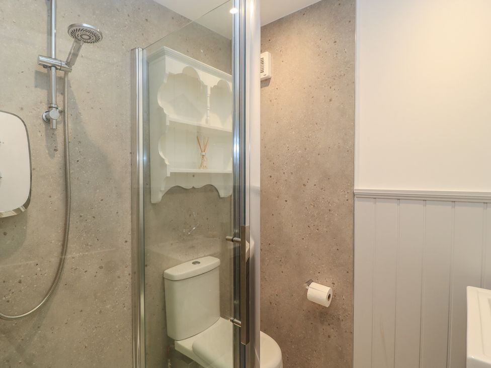 A bathroom with a shower and toilet at Still Waters in Swanage