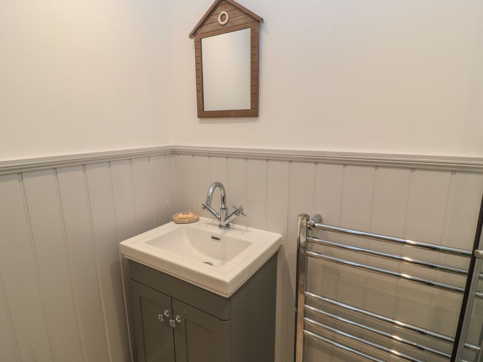 A bathroom with a sink and mirror at Still Waters in Swanage