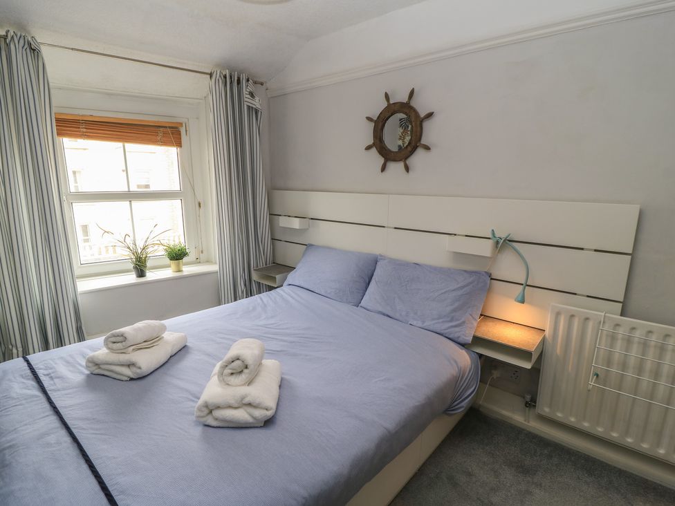 A bedroom with a bed and a window at Still Waters in Swanage