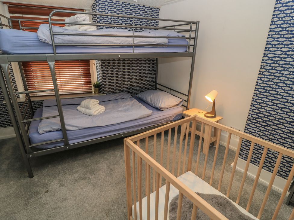 A bedroom with bunk bed and crib at Still Waters in Swanage