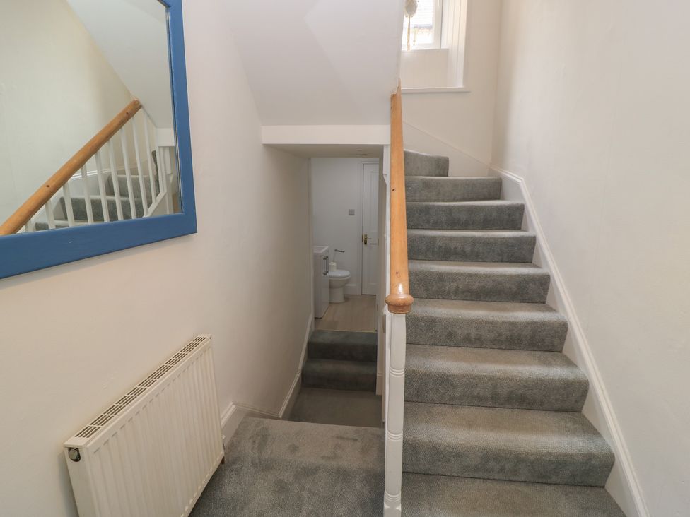 A staircase leading to upper floor with a toilet visible at Still Waters in Swanage