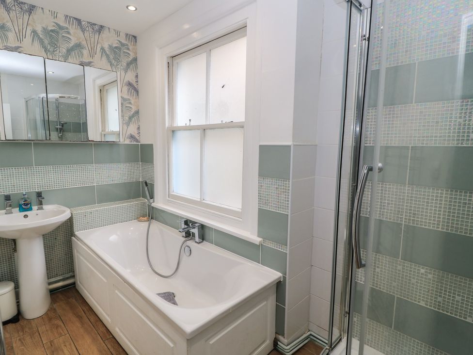 A bathroom featuring a bathtub, sink, and shower at Still Waters in Swanage