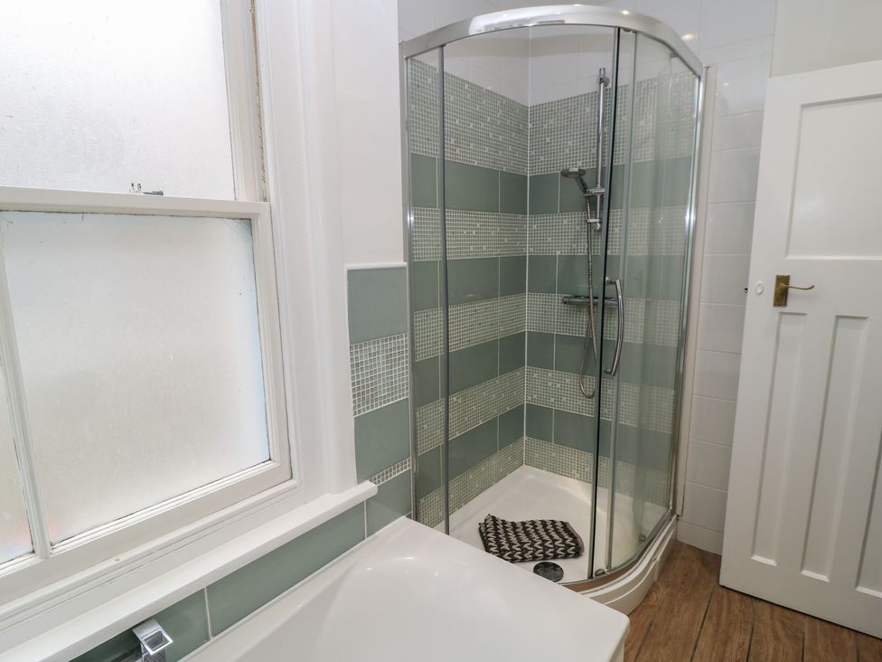 A bathroom with a shower and bathtub at Still Waters in Swanage