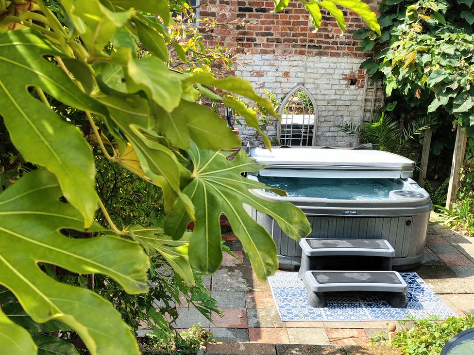 A hot tub with steps in a garden at Runnymede Tewkesbury