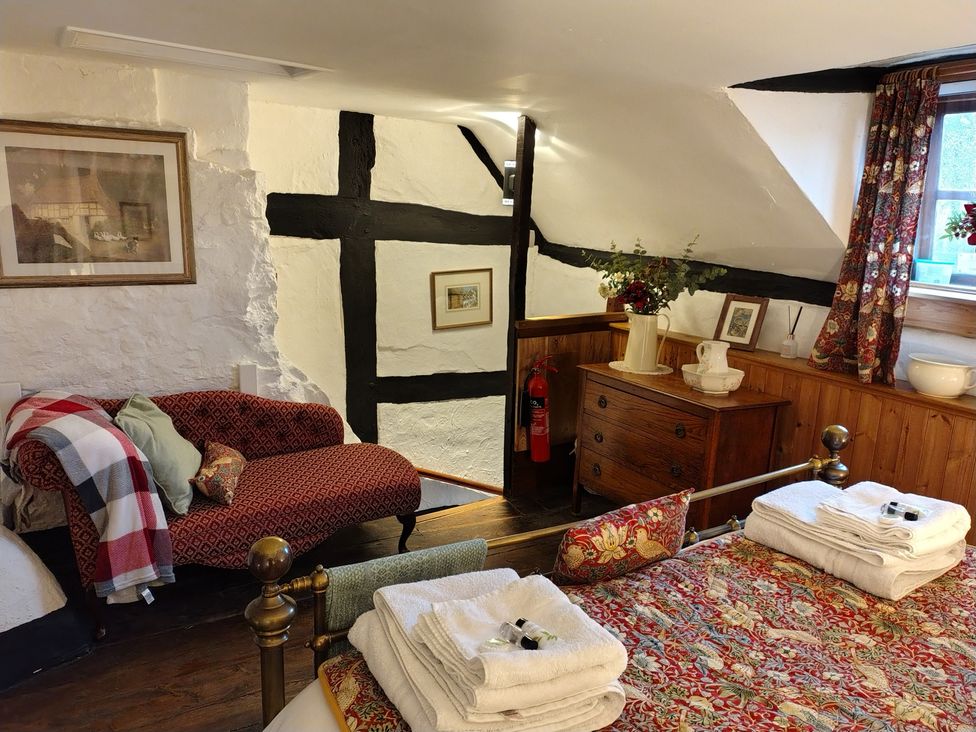 A bedroom with a sofa and a bed at Runnymede in Tewkesbury