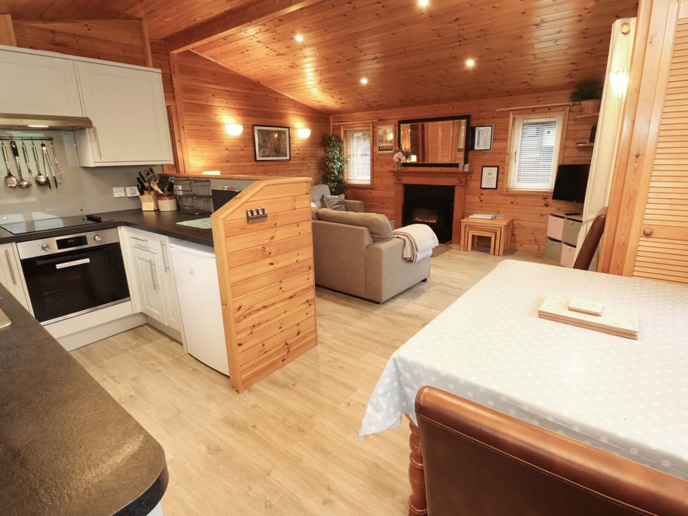 A living room with a kitchen area and a sofa at The Fold near Number 28, Burnside Park near Keswick