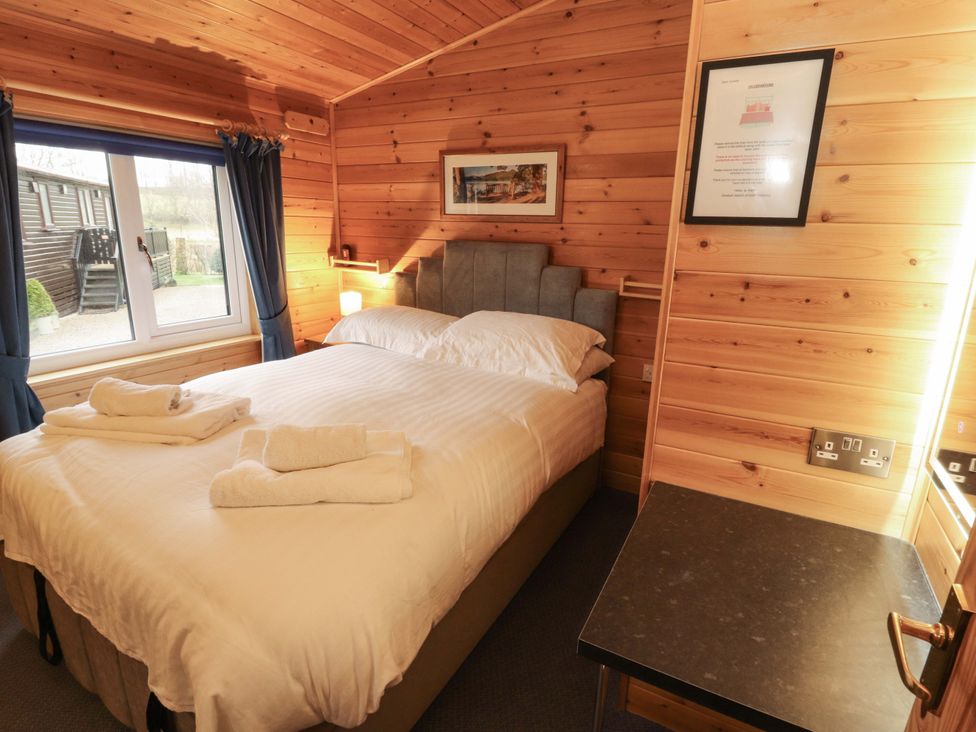 A bedroom with a bed and window at The Fold Number 28, Burnside Park near Keswick