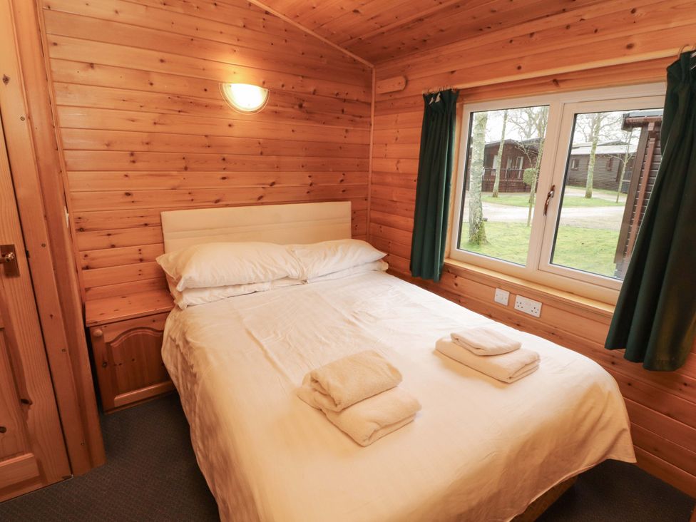 A bedroom with a bed and window at The Fold Number 28, Burnside Park near Keswick
