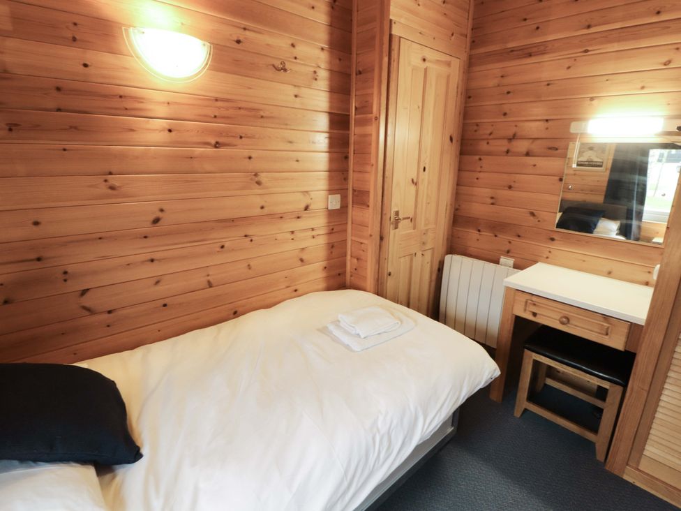 A bedroom with a single bed and desk at The Fold in Number 28, Burnside Park near Keswick
