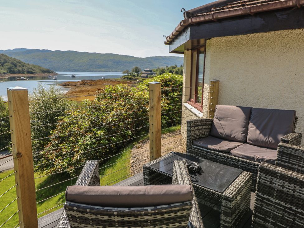 An outdoor seating area with furniture overlooking the water at Allt An Dorran in Salen