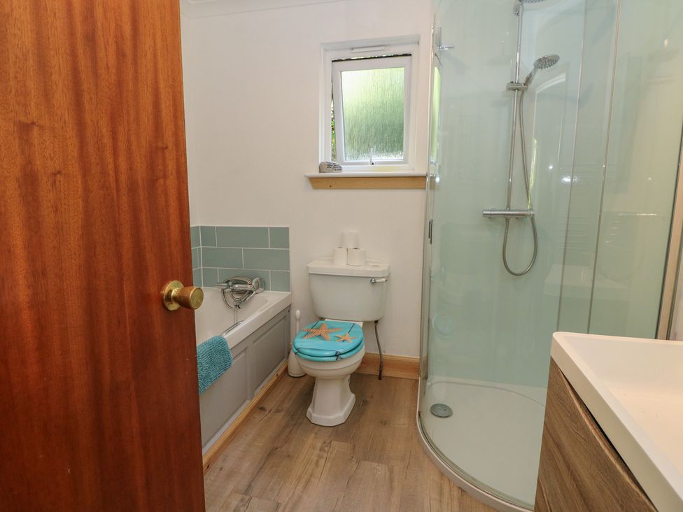 A bathroom with a bathtub, shower, toilet and sink at Allt An Dorran in Salen