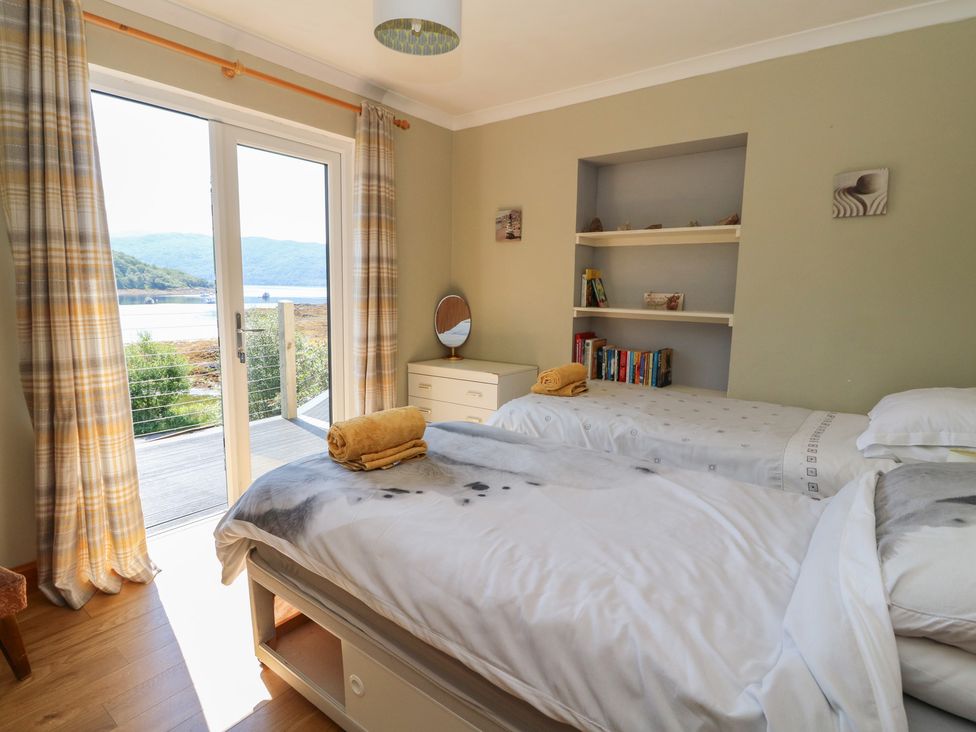 A bedroom with twin beds and a view of the outdoor area at Allt An Dorran in Salen