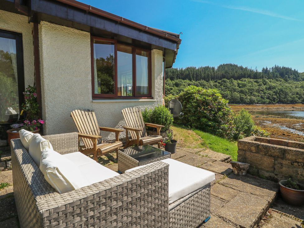 An outdoor seating area with a sofa and chairs at Allt An Dorran in Salen
