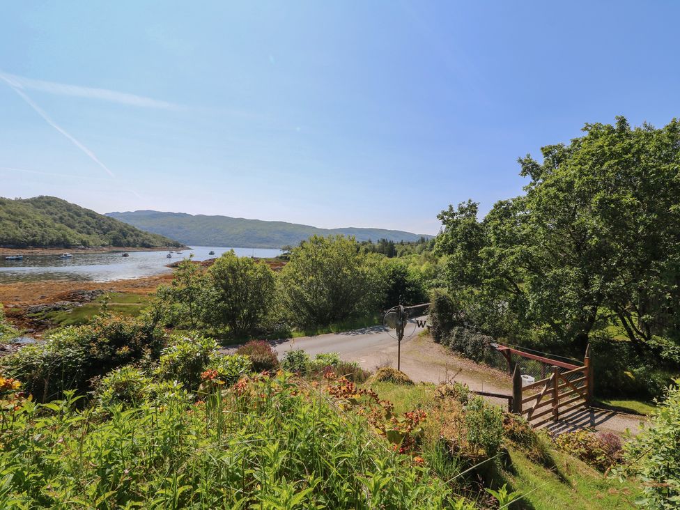 A view of water and trees near a road with a gate at Allt An Dorran in Salen
