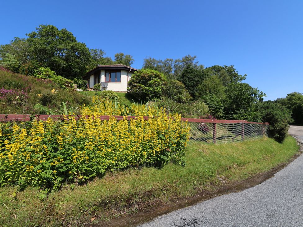A house with flowers and a fence at Allt An Dorran in Salen