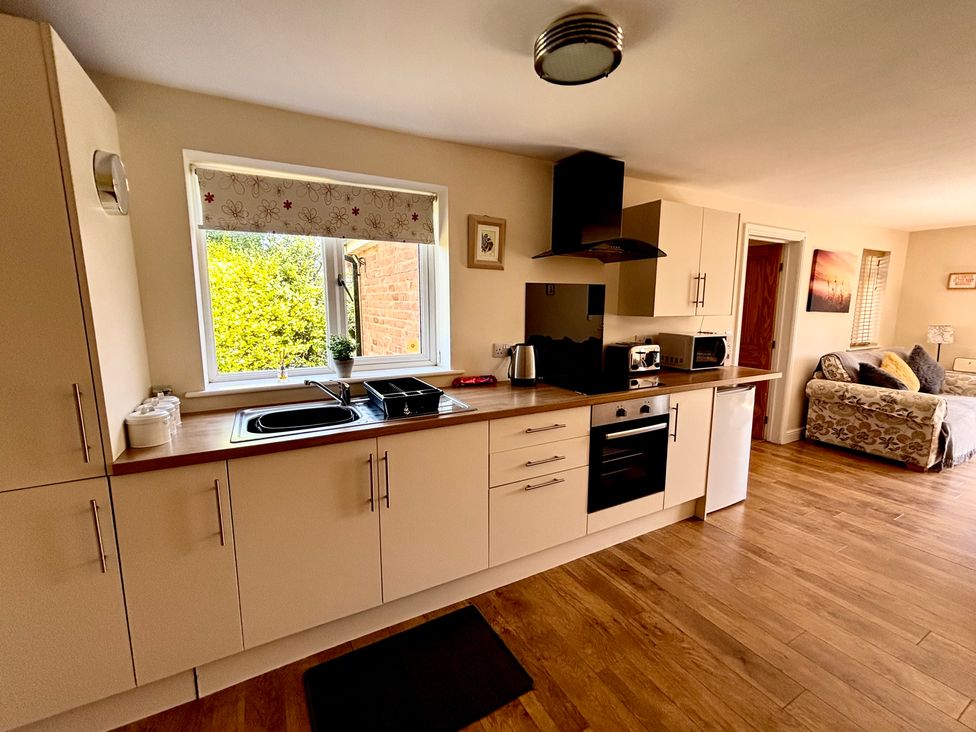 A kitchen with a sink stove and fridge at The Old Gate House Annexe Alford