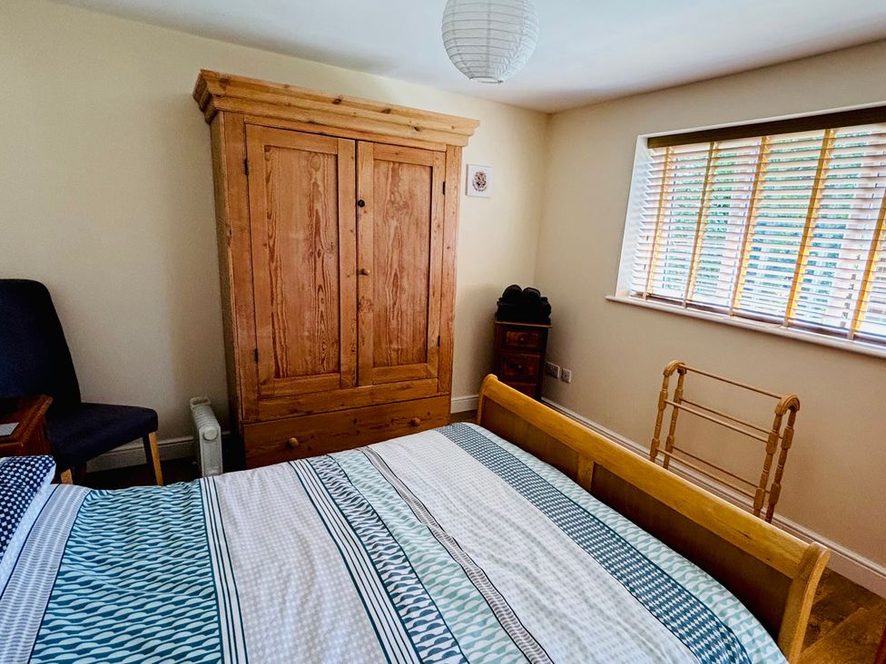A bedroom with a bed and wardrobe at The Old Gate House Annexe Alford