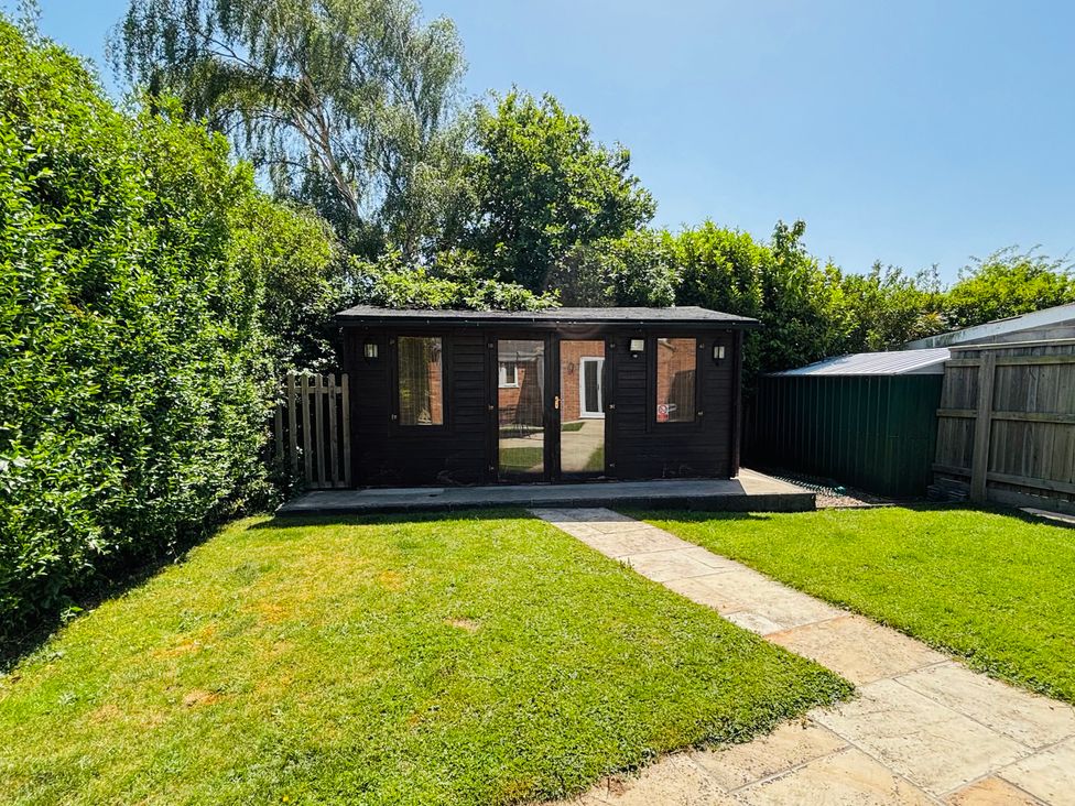A garden with a shed and pathway at The Old Gate House Annexe in Alford