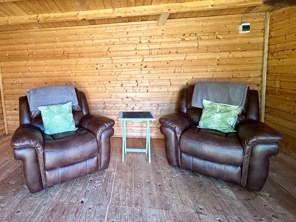 Two recliner chairs and a table in a snug at The Old Gate House Annexe Alford