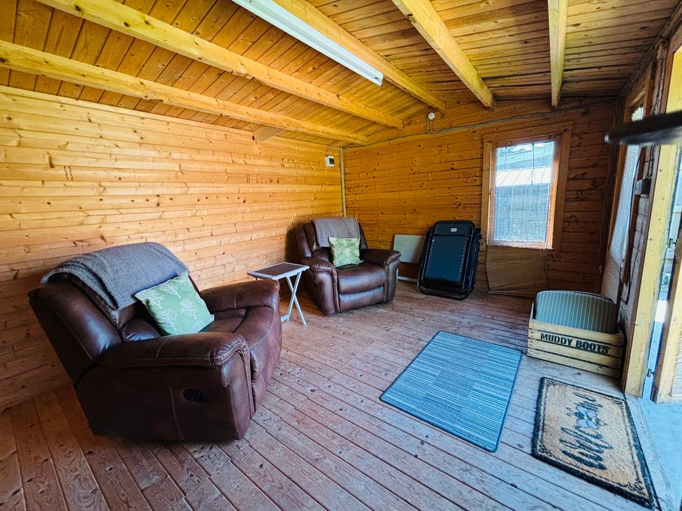 A snug with two recliners and a small table at The Old Gate House Annexe in Alford