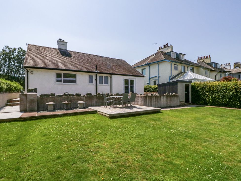 A garden with a house and patio area at Driftwood Cottage in Keswick