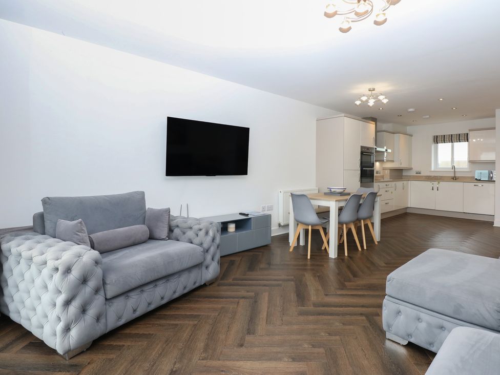 A living room with a sofa and television at 26 Awel Y Mor Pwllheli